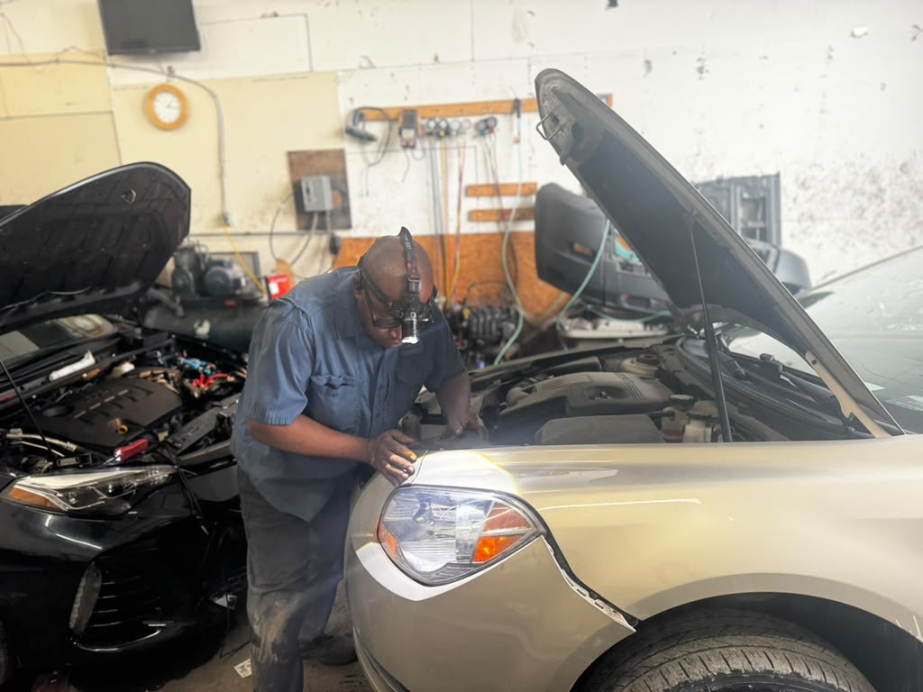 Eaglesoar technician inspecting the front end of a sedan with a magnifier work light